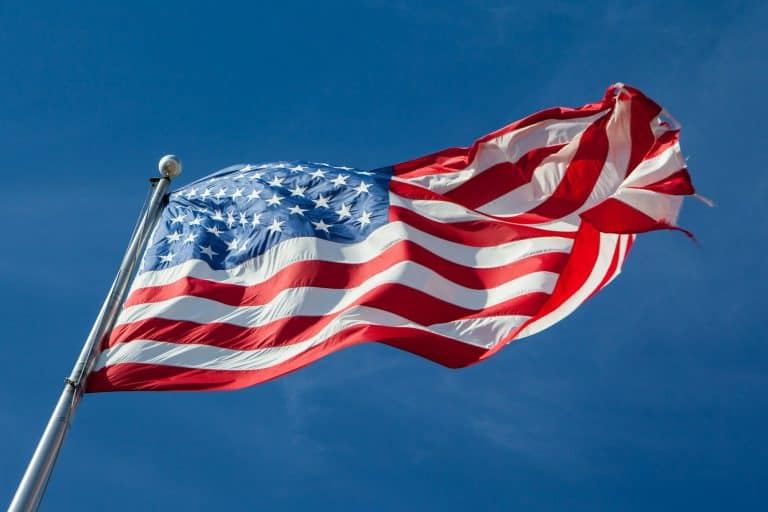 American flag waving in the wind against a blue sky.